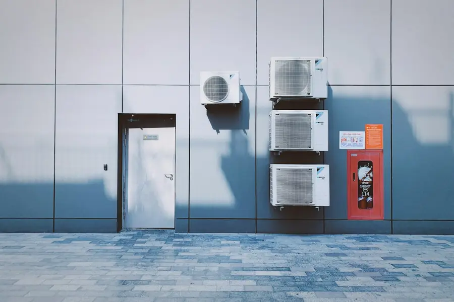 Row of outdoor air conditioning units mounted on a wall