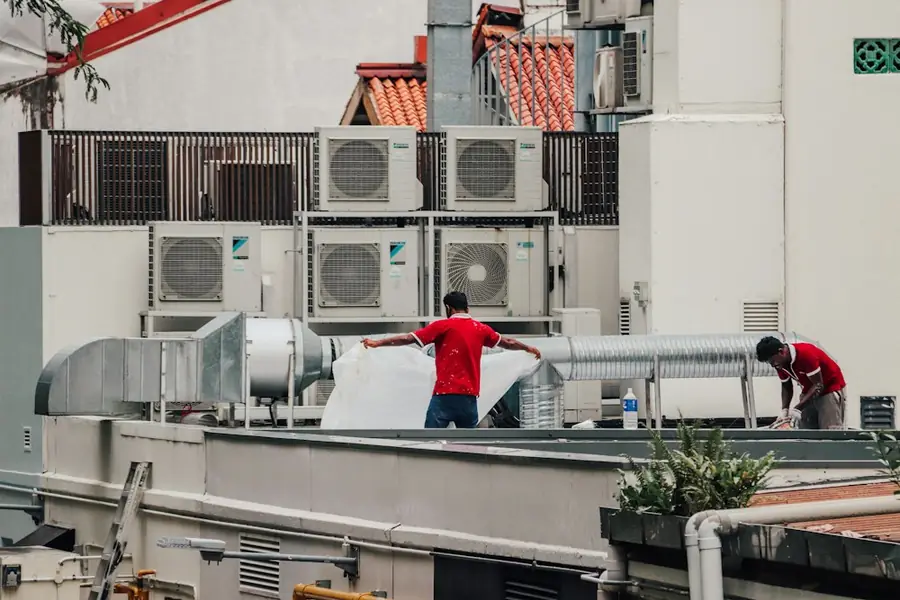 Technicians working on rooftop air conditioning plant
